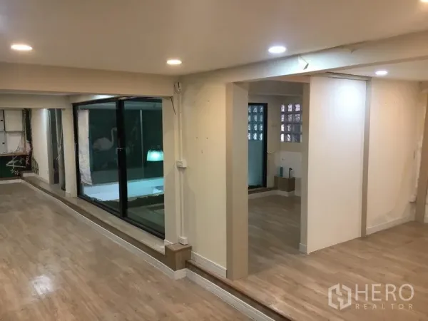 零售空间 出租在Watthana, Bangkok - 开放式零售内饰，木地板、筒灯与滑动玻璃隔断。