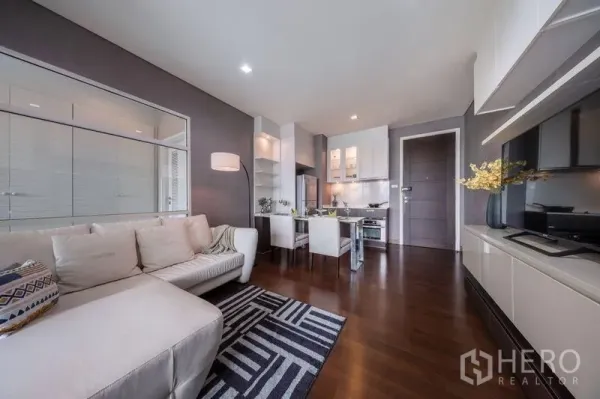 คอนโด ให้เช่าหรือขายในWatthana, Bangkok - โซนนั่งเล่นแบบโอเพ่นแพลนพร้อมโซฟา พรม โต๊ะทานข้าว และชุดครัว