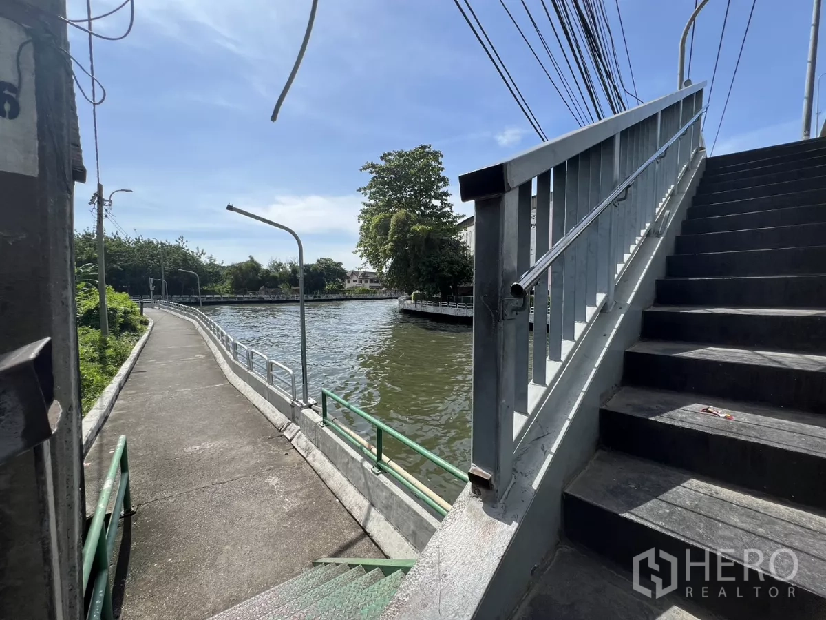 店屋 出售在Suan Luang, Bangkok - 临近房源的运河步道与人行桥，蓝天下的景致。