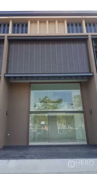 Home Office for rent in Pak Kret, Nonthaburi - Close-up of a glass-fronted home office entry with covered awning and a wide driveway.