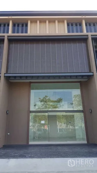 Home Office for rent in Pak Kret, Nonthaburi - Close-up of a glass-fronted home office entry with covered awning and a wide driveway.