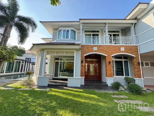 บ้าน ให้เช่าหรือขายในPrawet, Bangkok - ด้านหน้าบ้านกรุอิฐซุ้มโค้ง มีระเบียงชั้นสองและสนามหญ้าเขียวขจี