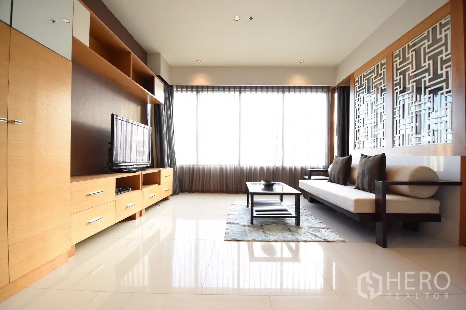 คอนโด ให้เช่าในKhlong Toei, Bangkok - ห้องรับแขกกว้าง มีชั้นวางทีวีบิวท์อิน พื้นกระเบื้องเงา และผนังลายเรขาคณิต