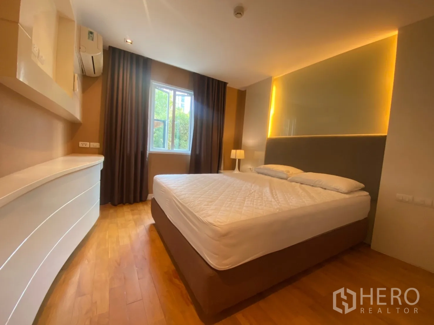 公寓 出租在Watthana, Bangkok - 转角卧室设大床与观景窗、深色窗帘和内置搁架。