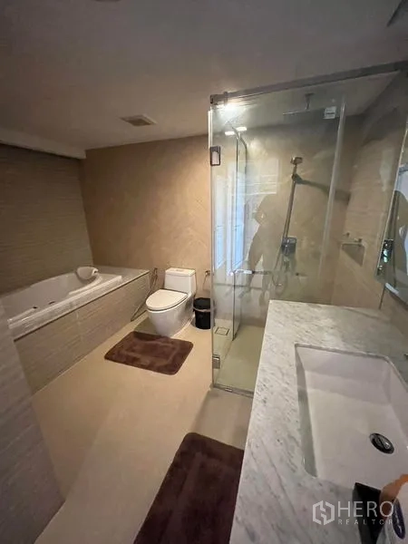 公寓 出售在Bang Rak, Bangkok - 浴室，石材台面、玻璃淋浴与浸泡浴缸。