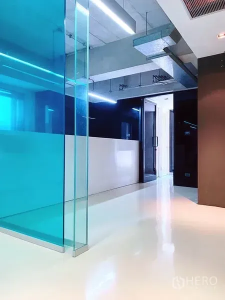 สำนักงาน ให้เช่าในPhaya Thai, Bangkok - โถงออฟฟิศพื้นสีขาวมัน ผนังกระจกสีฟ้า และไฟเส้นแบบลิเนียร์สู่ทางเข้าออฟฟิศ
