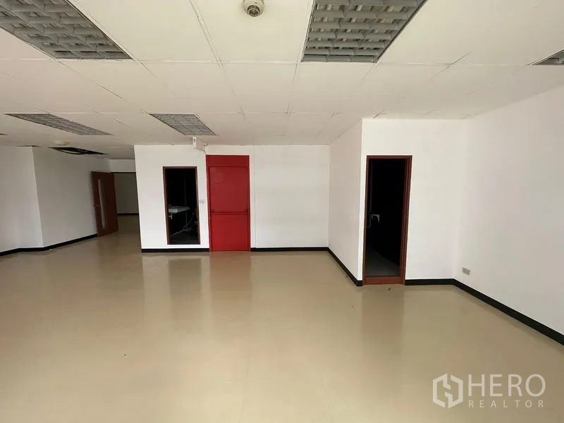 办公空间 出租在Pathum Wan, Bangkok - 主办公区，多个门洞，红色防火门与米色地面。