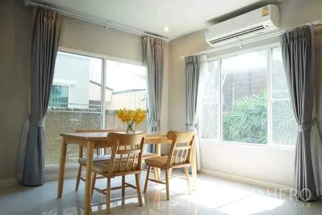 Detached House for rent in Bang Phli, Samut Prakan - Sunlit dining corner opening to the garden through sliding doors, set with a small wooden table.