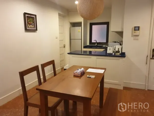 คอนโด ให้เช่าหรือขายในKhlong Toei, Bangkok - โต๊ะทานอาหารติดครัวขนาดเล็ก เคาน์เตอร์สีน้ำเงิน อ่างล้างจาน และตู้เย็นในคอนโดตกแต่งพร้อมอยู่.