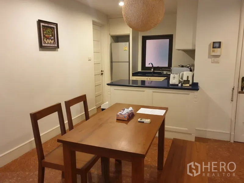 คอนโด ให้เช่าหรือขายในKhlong Toei, Bangkok - โต๊ะทานอาหารติดครัวขนาดเล็ก เคาน์เตอร์สีน้ำเงิน อ่างล้างจาน และตู้เย็นในคอนโดตกแต่งพร้อมอยู่.