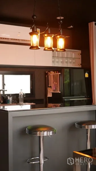 Detached House for rent or sale in Bang Bo, Samut Prakan - Kitchen bar with hanging lantern pendant lights and chrome stools.