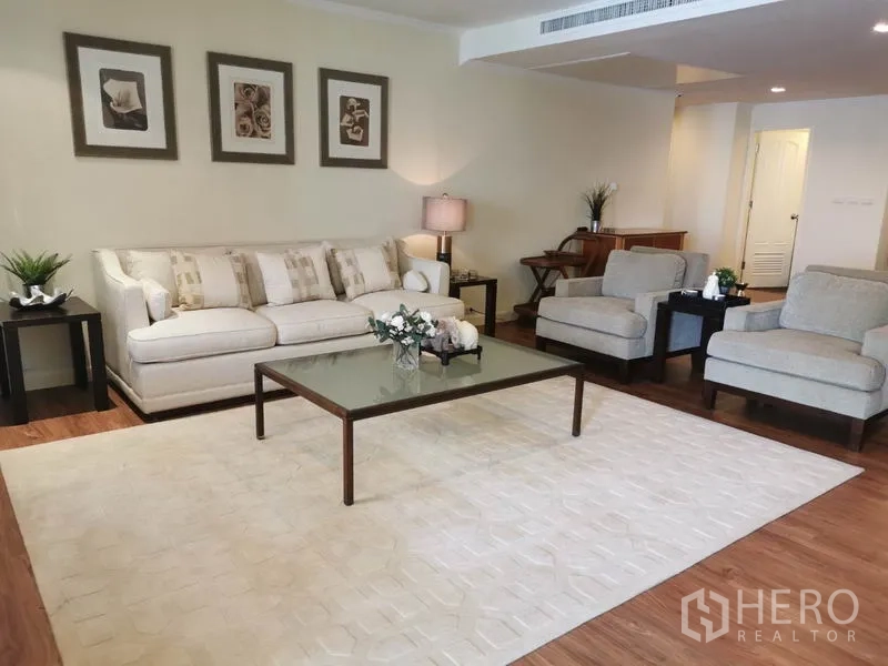 Condominium for rent in Watthana, Bangkok - Spacious lounge with sofa set, armchairs, area rug and side tables.