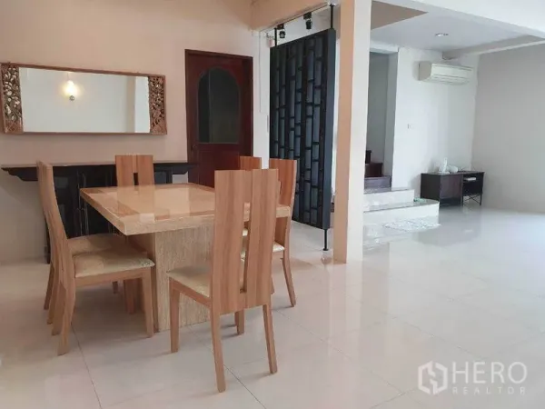 独立式住宅 出租在Phra Khanong, Bangkok - 餐厅与客厅相连的开放式空间，亮面地砖与空调。