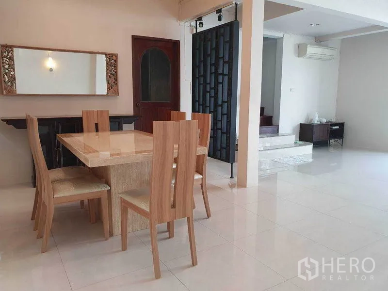 独立式住宅 出租在Phra Khanong, Bangkok - 餐厅与客厅相连的开放式空间，亮面地砖与空调。