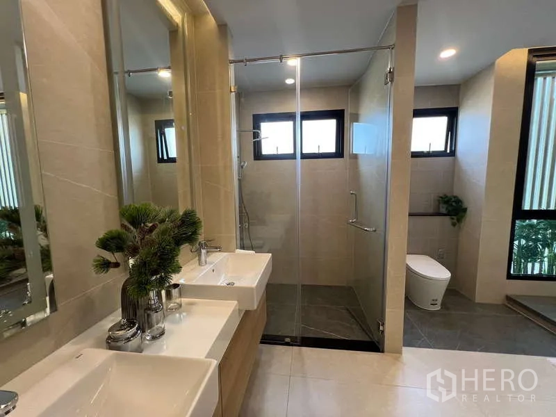 Detached House for sale in Suan Luang, Bangkok - Modern bathroom with double vanity, glass-enclosed shower and windows