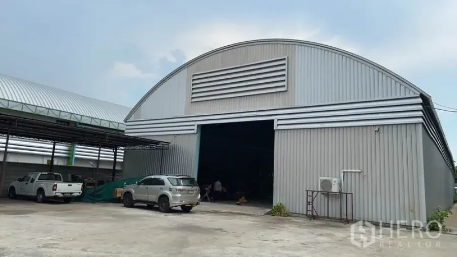 货栈 出租在Lak Si, Bangkok - 拱形金属屋顶的大型仓库外观，超宽入口与混凝土堆场，位于曼谷Lak Si。