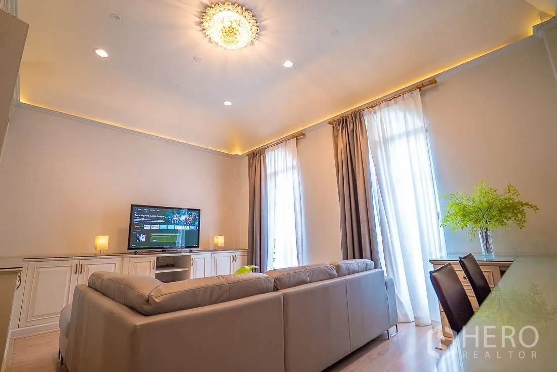 联排别墅 for rent in Yan Nawa, Bangkok - 挑高客厅，吊灯、沙发组与窗边工作台。