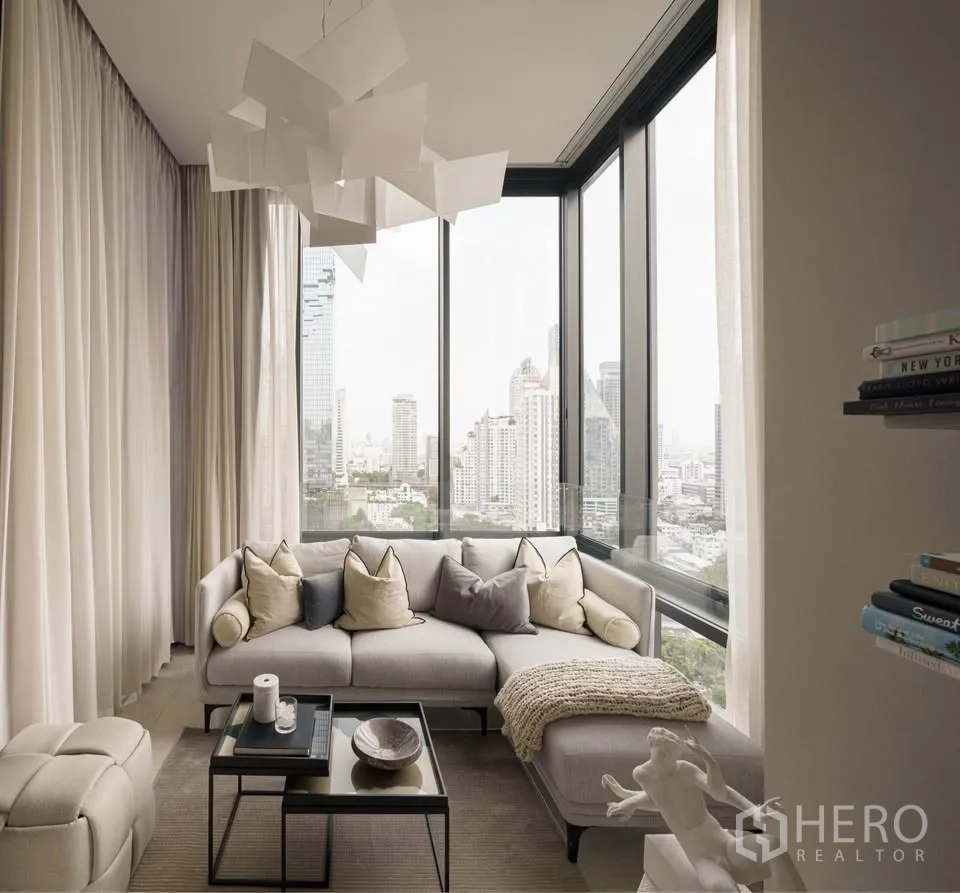 Condominium for rent in Bang Rak, Bangkok - Corner living area with L-shaped sofa and panoramic city skyline through full-height windows.