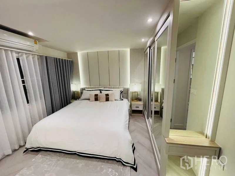 Condominium for sale in Yan Nawa, Bangkok - Spacious master bedroom with white bedding, backlit headboard, and mirrored closet.
