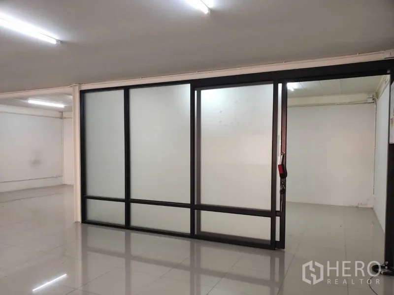 Home Office for rent in Pathum Thani - Bright office area with frosted glass sliding partitions and glossy tiled floors.