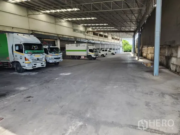 工厂 出租在Mueang Samut Sakhon, Samut Sakhon - 高棚装卸区，多辆货车停靠在雨棚下。