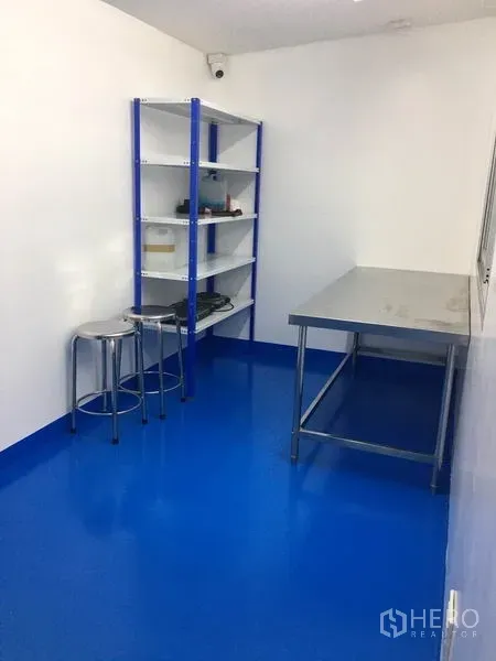 工厂 出租或出售在Pathum Thani - 紧凑的准备室，金属置物架、吧椅和不锈钢工作台。