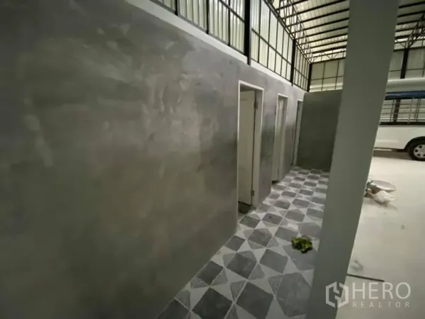 货栈 出租在Saphan Sung, Bangkok - 仓库内的走廊，水泥墙面，多个房门与几何花纹地砖。