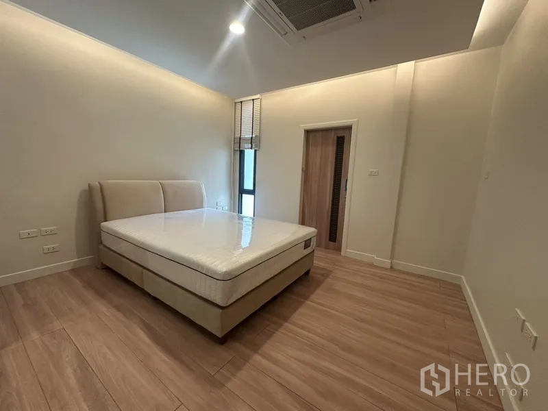 ทาวน์เฮาส์ ให้เช่าในWatthana, Bangkok - ห้องนอนอบอุ่น เตียงบุผ้า พื้นไม้ และประตูห้องน้ำในตัว