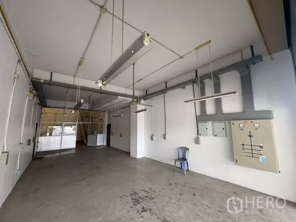 คลังสินค้า ให้เช่าในBang Phli, Samut Prakan - พื้นที่โกดังชั้นล่าง มีโคมไฟแขวนและตู้ไฟฟ้า