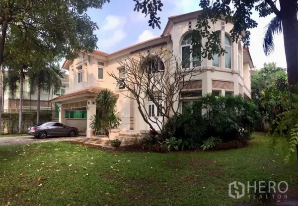 独立式住宅 出租或出售在Lat Phrao, Bangkok - 两层独栋别墅外观，车道停车位与修剪整齐的草坪。