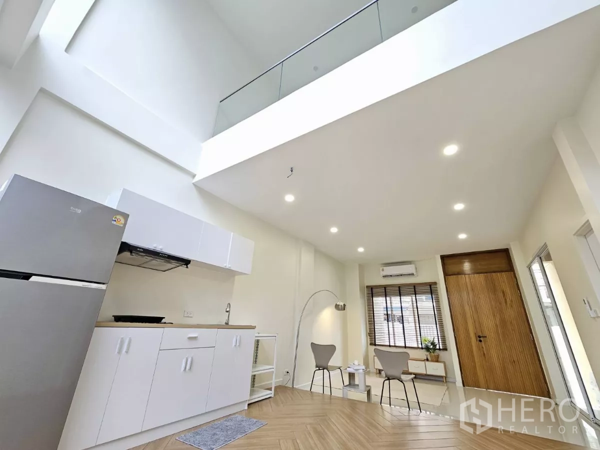 联排别墅 出售在Lat Phrao, Bangkok - 客厅与茶水间，6.15米挑高天花与高窗