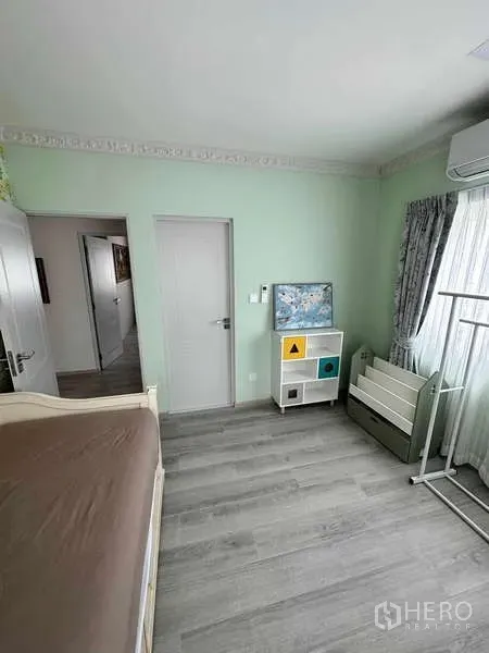 Detached House for sale in Bang Phli, Samut Prakan - Bedroom corner with pastel green walls, wardrobe and nursery furniture