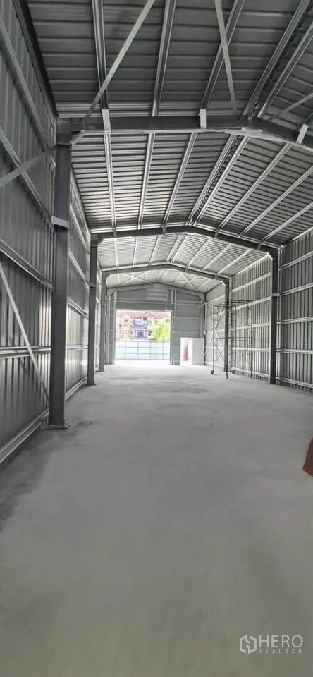 Warehouse for rent in Lat Phrao, Bangkok - Long interior view of the high-ceiling warehouse with steel trusses and concrete floor.