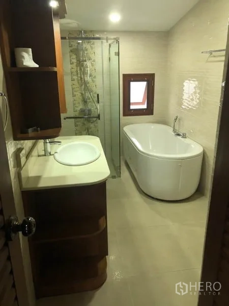 Detached House for rent in Watthana, Bangkok - Modern bathroom with soaking tub, glass shower and vanity.