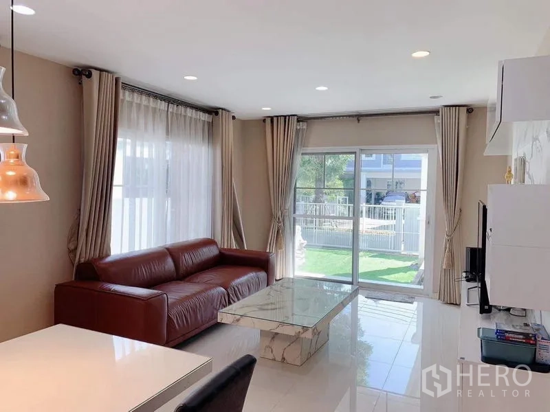 独立式住宅 出租或出售在Bang Phli, Samut Prakan - 采光充足的客厅，通过大推拉门望向花园