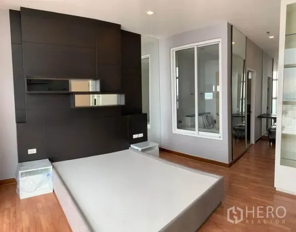公寓 出租或出售在Bang Na, Bangkok - 宽敞卧室，深色特色墙带置物与镜面，大窗采光好，木地板。