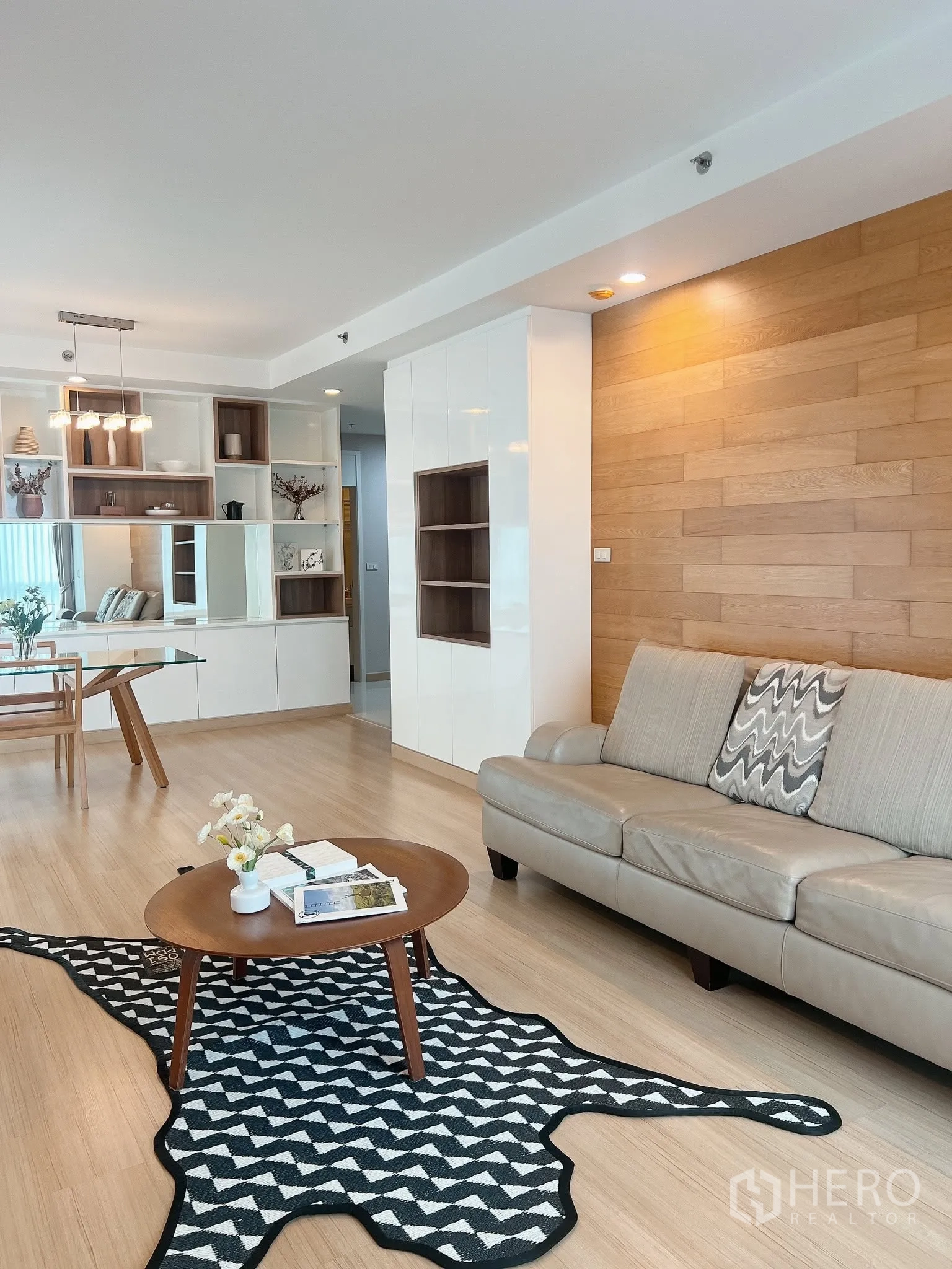 คอนโด for rent in Pathum Wan, Bangkok - รายละเอียดห้องนั่งเล่น ผนังลายไม้ โซฟา โต๊ะกาแฟกลม และชั้นวางของ