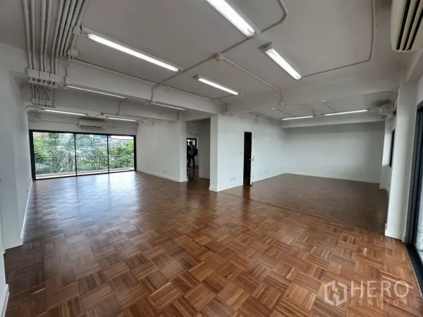 办公空间 出租在Watthana, Bangkok - 宽敞工作空间，外露管道照明，木地板与大窗，视野面向树景。