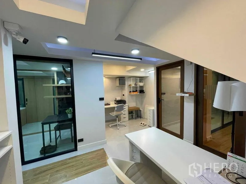 สำนักงานที่บ้าน ให้เช่าหรือขายในBang Kapi, Bangkok - ด้านหน้าอาคารโฮมออฟฟิศพร้อมโรงจอดรถและไฟแนวตั้งยามค่ำ