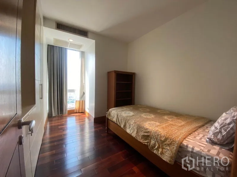 公寓 出租在Sathon, Bangkok - 次卧配单人床、书架、木地板与带窗帘的高窗。