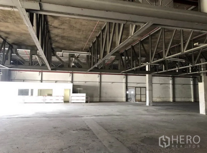 Warehouse for rent in Lam Luk Ka, Pathum Thani - Close-up of steel mezzanine structure and open work area inside the warehouse.