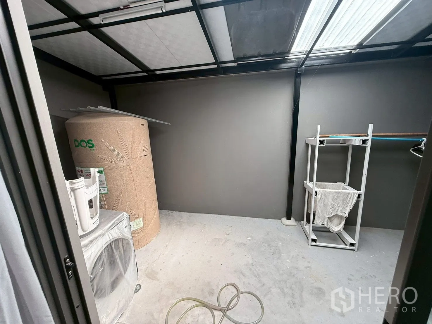 Townhouse for rent in Bang Phli, Samut Prakan - Laundry zone with water tank, washing machine and drying stand under a roof.