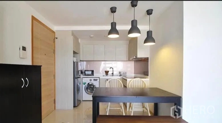 คอนโด ให้เช่าหรือขาย - ครัวสีขาวสมัยใหม่ โคมไฟห้อย โต๊ะกินข้าว พร้อมตู้เย็นและเครื่องซักผ้า