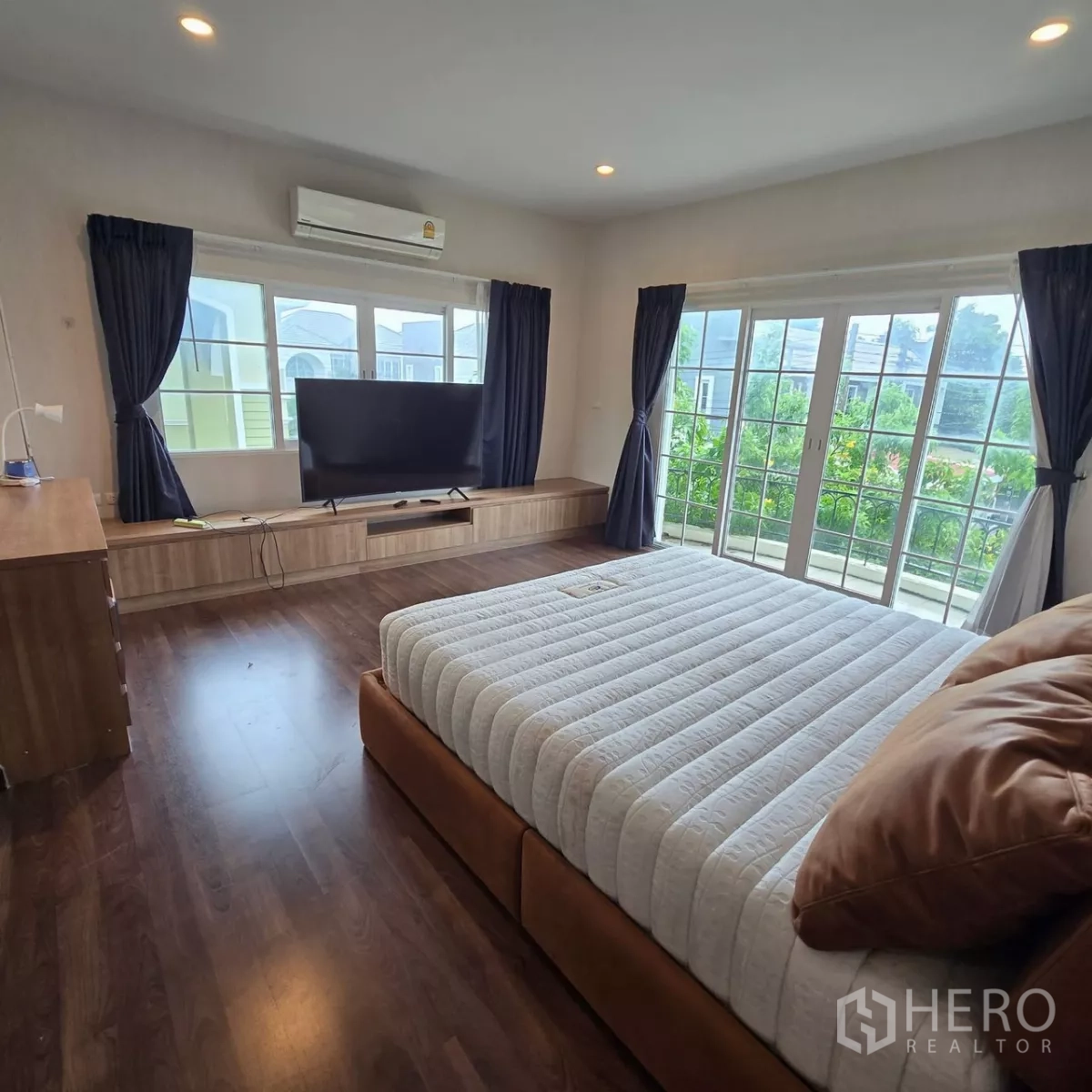 บ้าน ให้เช่าในMueang Pathum Thani, Pathum Thani - ห้องนอนมาสเตอร์สว่าง มีประตูระเบียง ทีวีคอนโซล และเตียงคิง