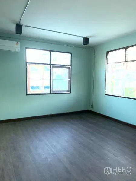 独立式住宅 出租或出售在Phra Khanong, Bangkok - 明亮房间，双窗、空调与深色木纹地板。