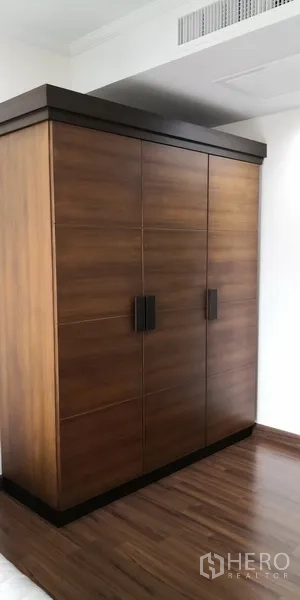 Condominium for rent in Sathon, Bangkok - Spacious wooden wardrobe in the bedroom with engineered wood flooring.