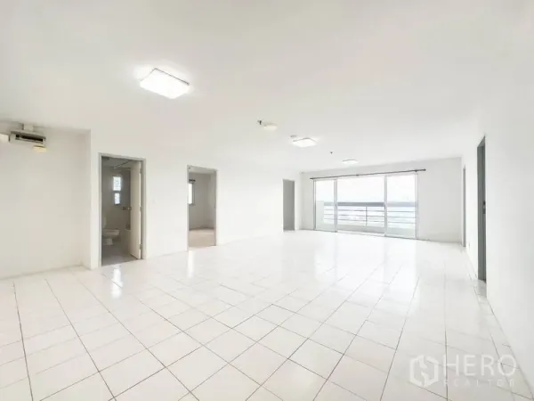 คอนโด ขายในBang Na, Bangkok - ห้องนั่งเล่นปูกระเบื้องสีขาวกว้าง เชื่อมระเบียงกระจกมองวิวเมือง.