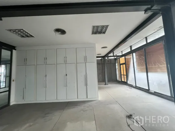 零售空间 出租在Watthana, Bangkok - 整面白色储物柜，旁边是落地窗的零售区域