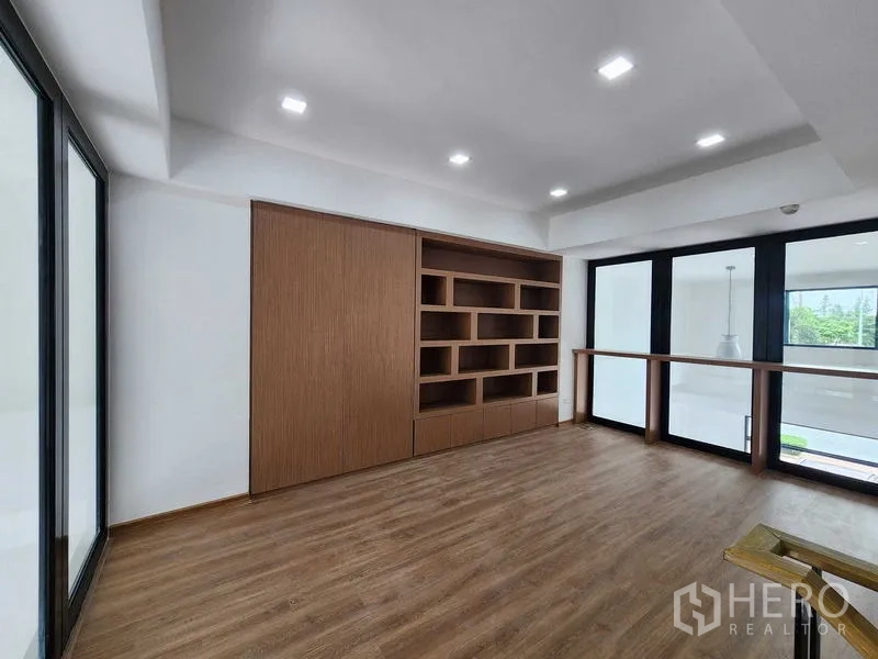 带办公室的家 出租在Prawet, Bangkok - 夹层配有定制木质书柜与整扇玻璃门，可俯瞰入口大堂。