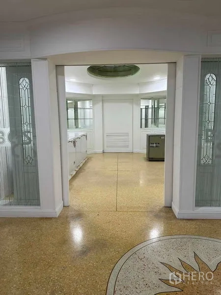 Home Office for sale - Hallway with decorative textured glass panels, built-in counters and terrazzo floor medallion.